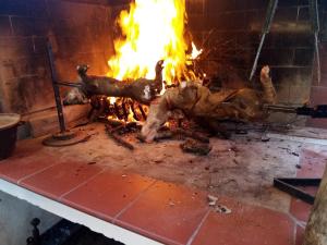 a piece of meat being cooked in a fireplace at Casa Gioconda Bed & Breakfast in Nuxis