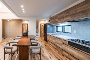a kitchen with a wooden table and some chairs at Apartment Hotel 11 Villa Hanazonocho in Osaka