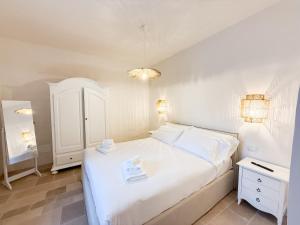 a bedroom with a white bed and a white cabinet at Borgo Cucumo by MONHOLIDAY in Castellana Grotte