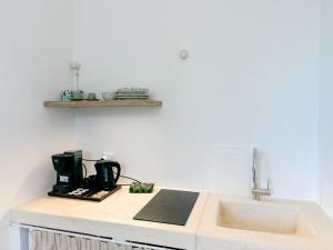 a kitchen counter with a sink and a coffee maker at Borgo Cucumo by MONHOLIDAY in Castellana Grotte