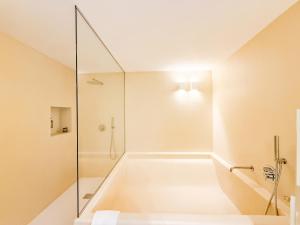 a bathroom with a shower and a bath tub at Borgo Cucumo by MONHOLIDAY in Castellana Grotte +25 photos