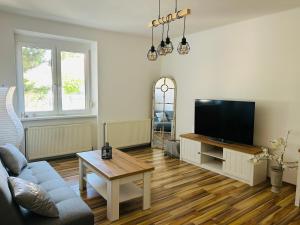 a living room with a tv and a table at Guesthouse Tulln in Tulln