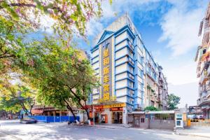 a building with a sign on the side of it at Xinghe Xinfeng Hotel Railway Station & Bus Station Branch in Guangzhou