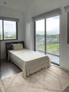 イロイロにあるSerene Stays 2 Bedroom Flatの大きなベッドと大きな窓のある寝室
