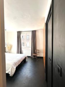 een slaapkamer met een bed en een raam bij design apartment in Parijs