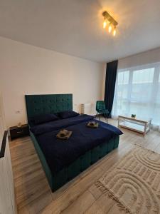 a bedroom with a large bed with two towels on it at Studio Râșnov VMP Free Parking in Râşnov