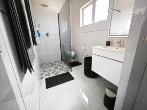 ein weißes Badezimmer mit Dusche und Waschbecken in der Unterkunft Kys Place in Durban + 27 Fotos