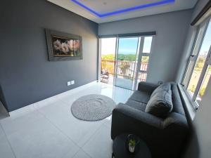 ein Wohnzimmer mit Couch und großem Fenster in der Unterkunft Kys Place in Durban