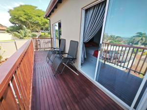 einen Balkon mit 2 Stühlen auf einer Terrasse in der Unterkunft Kys Place in Durban