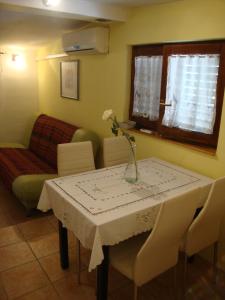 Apartment Kaucic في بنجول: غرفة معيشة مع طاولة مع إناء من الزهور عليها