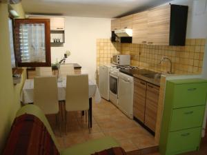 Apartment Kaucic في بنجول: مطبخ مع طاولة ومطبخ مع دواليب خضراء