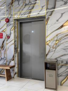 Una puerta de ascensor en un edificio con una pared de mármol. en Pepper Inn, en Sibu