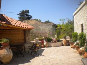a patio with chairs and potted plants and a fence at Marias Alikambos in Alikampos
