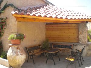 a patio with a table and chairs and a bench at Marias Alikambos in Alikampos +1 photo