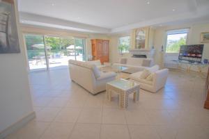 a living room with white furniture and a fireplace at Charmante villa avec grande piscine au calme in Callian