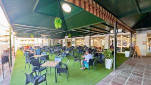 eine Gruppe von Personen, die an Tischen und Stühlen sitzen in der Unterkunft BENALBEACH Vista al Mar in Benalmádena