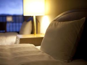 - un lit dans une chambre d'hôtel avec un oreiller blanc dans l'établissement Suigekka, à Wakasa