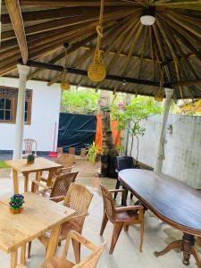 un patio al aire libre con mesas y sillas de madera en Sandy Coconut Guest, en Mirissa