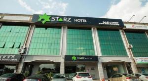 a star hotel with cars parked in front of it at Starz Hotel in Kluang
