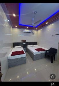 1 dormitorio con 2 camas y TV en el techo en Samruddhi Groups, en Mādhavaram