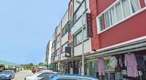 a street with cars parked in front of a building at OYO 90431 CZ Hotel in Pasir Puteh