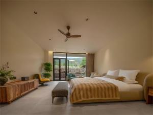 a bedroom with a bed and a ceiling fan at Yunshui Shenshen Rizhao Jinshan Panoramic Secret Resort Hotel in Lijiang