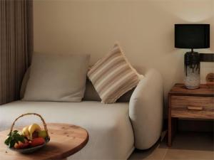 a bed with a bowl of fruit and a pillow at Yunshui Shenshen Rizhao Jinshan Panoramic Secret Resort Hotel in Lijiang