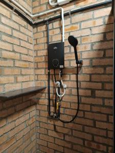 eine Dusche ist an einer Ziegelwand befestigt in der Unterkunft Single-Storey Bungalow 1 to 14pax Industrial Style in Pelabuhan Kelang