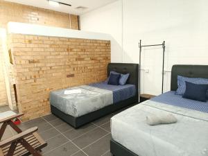 zwei Betten in einem Zimmer mit einer Ziegelwand in der Unterkunft Single-Storey Bungalow 1 to 14pax Industrial Style in Pelabuhan Kelang + 38 Fotos