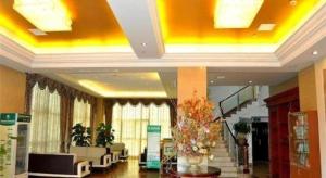 a lobby with a staircase and a room with flowers at GreenTree Inn Zhoushan New Town Hotel in Zhoushan