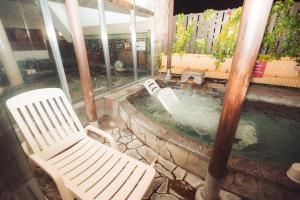a pool of water with two white chairs and a table at バーデンガーデン 旧ザベッドアンドスパ in Tokorozawa
