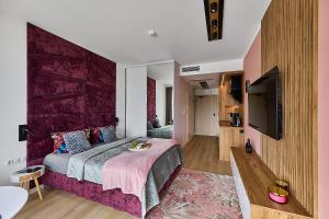 a bedroom with a large bed and a tv at Baltic Infinity Apartments in Międzyzdroje