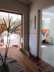 a dining room table with a vase with a plant on it at Caledon 31 in George