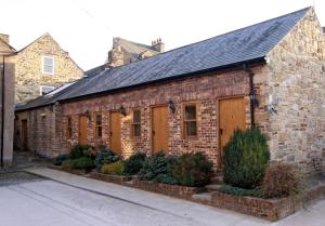 a brick building with wooden doors on a street at Centre Of Britain Hotel in Haltwhistle