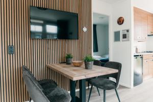 Una mesa de comedor con sillas y un televisor en la pared. en Recreatiepark de Boshoek, en Voorthuizen 11 fotos más
