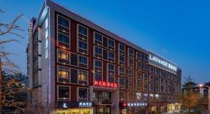 済南市にあるLavande Hotel Ji'nan Railway Station Long Distance Bus Terminalの側面に看板がある大きな建物