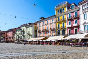 una via cittadina con tavoli, sedie ed edifici di Bottega del Vino Guesthouse a Locarno