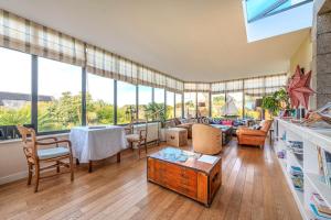 La Demeure Océane في Portsall: غرفة معيشة مع الكثير من النوافذ