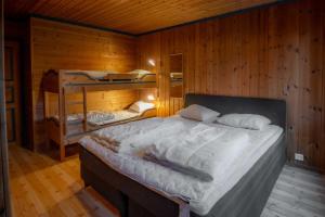 un dormitorio con una cama y dos literas en Bakkebyvegen 7B, en Trysil 9 fotos más