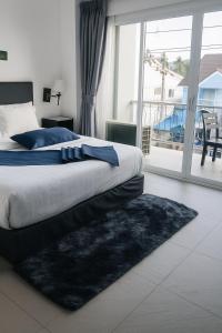 a bedroom with a bed and a large window at Lipa Noi Hostel in Amphoe Koh Samui