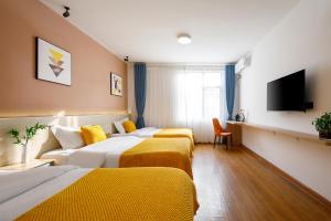 una habitación de hotel con dos camas y un sofá en Huangshan Yunyi B&B, en Tangkou