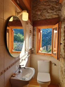 a bathroom with a sink and a toilet and a mirror at Casa Rural Haiku in Bojar