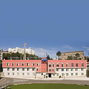 a large red and white building in a city at Hotel Apartamentos Dabarca in Pontevedra