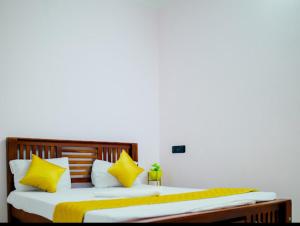 1 Schlafzimmer mit 2 Betten mit gelben und weißen Kissen in der Unterkunft La French villa in Puducherry