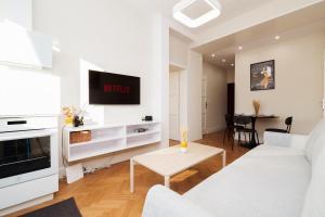 a white living room with a white couch and a table at Charming train lines studio in Vinohrady