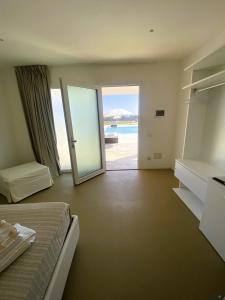 a bedroom with a bed and a door to the ocean at Agricola Chiani in Melendugno
