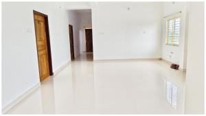 une chambre vide avec des murs blancs et une porte en bois dans l'établissement Hotel Shree Laxmi Resorts - Patia Railway Station- Fully Air Conditioning Hotel - Luxury & Spacious Room -A Premium Hotel, à Cuttack