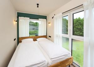 a bedroom with a bed and a large window at Luxuscontainer am Nürburgring #4 in Adenau