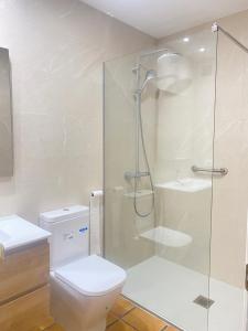 a bathroom with a toilet and a glass shower at Beach house with pool at the Fortí viewpoint in Altafulla +12 photos