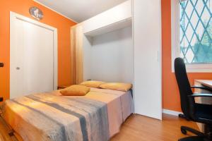 a bedroom with orange walls and a bed with yellow pillows at Dreams To Lake Como in Senna Comasco
